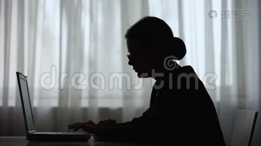 女性在笔记本电脑上的智能手机上阅读信息的影子，自由职业者视频