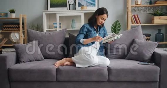 在漂亮的公寓里，漂亮的女孩在家里轻松地读书视频