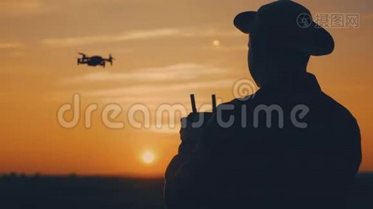 日落时分，一个农民在麦田里使用无人机的剪影。 增加概念技术创新视频