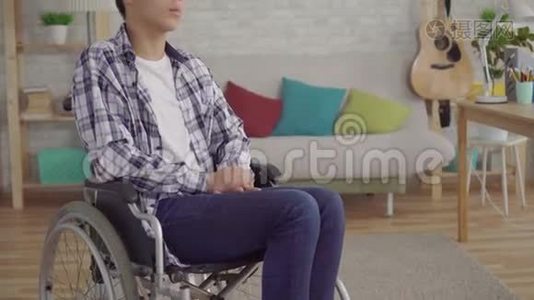 厌倦了无聊的亚洲年轻人在家里坐轮椅视频
