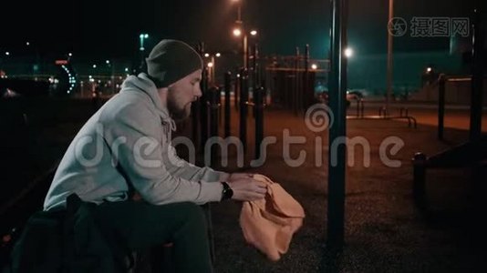 疲惫的男运动员在夜间在户外运动场的塔台上擦脸视频