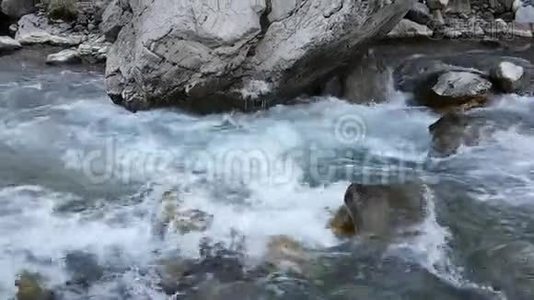 湍急的流水在一条山河里流淌.. 秋天，春天，冬天的季节。 冰冻冰柱在岩石上视频