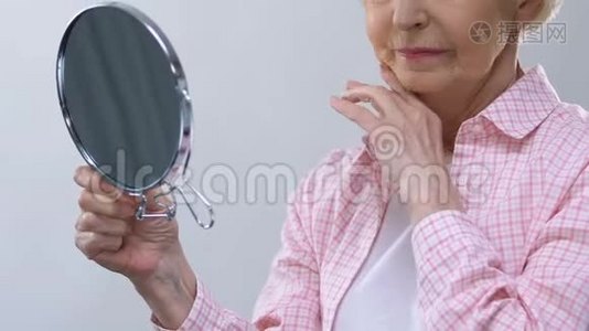 年老的女人照镜子，摸着皱纹的脸，想着失去的美丽视频