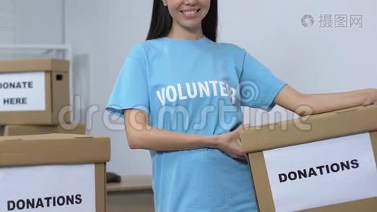 开放的女性志愿者手持捐款箱，微笑着对着镜头，关怀视频