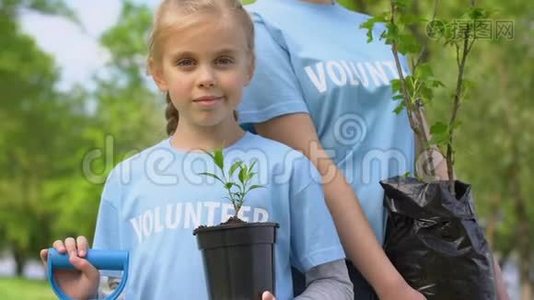 女孩和母亲拿着植物树苗和铲子，环境志愿服务视频