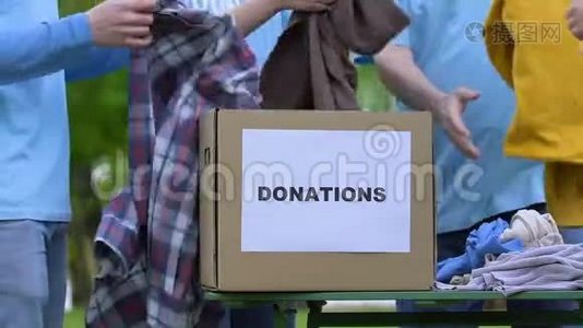 志愿者小组把衣服放进捐赠箱，孤儿院慈善项目帮助视频