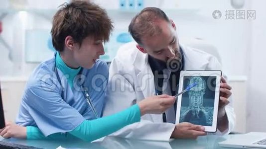 医生和年轻护士在数字平板电脑上看核磁共振CT X线扫描视频