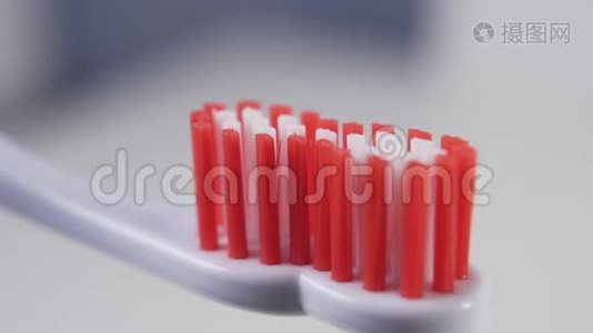 把蓝色牙膏挤到浴室里塑料牙刷的红色刚毛上视频