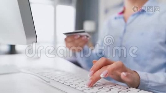 女性手在电脑键盘上输入信用卡号码。 女人在网上购买。 在线支付服务。视频