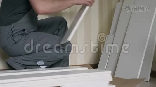 工人在组装前先把白色木制家具的部件拆开视频