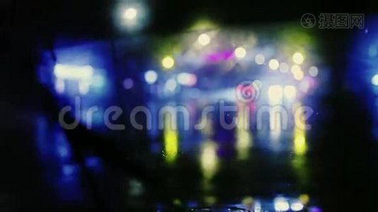 雨滴与街上五颜六色的交通灯在夜间模糊，背景抽象，老式的颜色色调，凉爽的寒冷视频