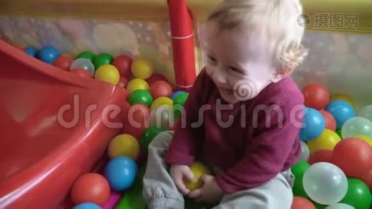 可爱的小男孩在游戏室里玩球和微笑视频
