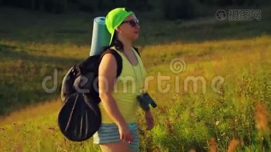 女徒步旅行者肩上背着背包，用双筒望远镜登山视频
