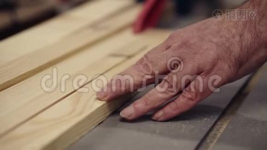 慢动作木工在锯木机上皱手切割木板.. 切割圆锯的工业机器视频