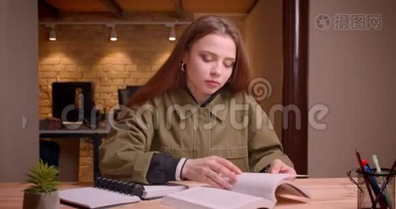 年轻少女读书时专心写作业的画像变成办公室里的书。视频