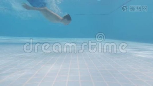这个男孩在游泳池里的水下游泳，然后拿着一个动作摄像机出现了视频