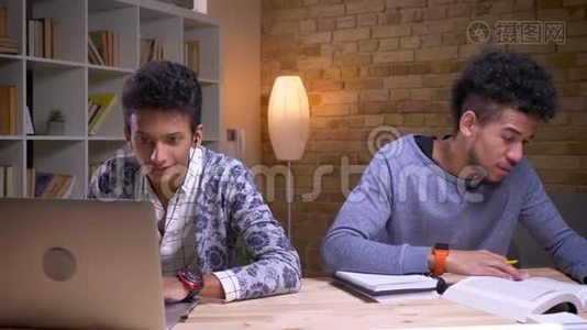 印度男性使用笔记本电脑，开心地微笑着听音乐的特写镜头和非裔美国人视频