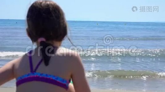 小女孩跑进了海水里。视频