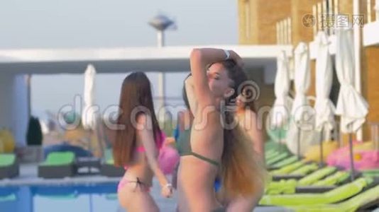 周末在昂贵的度假胜地游泳池边穿着泳装和迷人的女孩结伴而行视频
