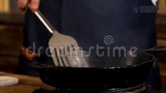 用黑色铁锅将男厨炒制的食材合上，用金属铲子搅拌.. 库存录像。 流程视频