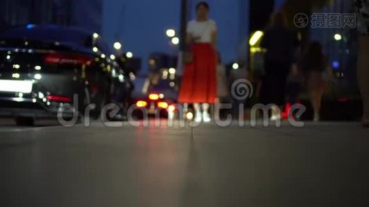 城市街道的分散视野。 穿红色裙子的女孩站在人行道上视频