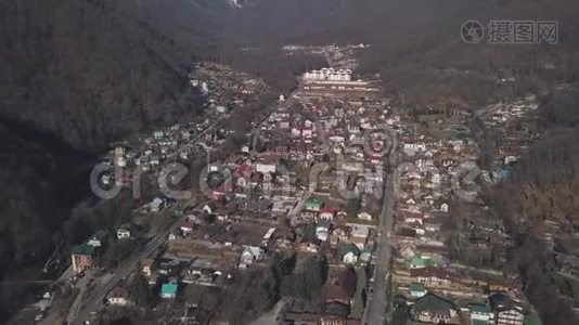 鸟瞰冬季奥地利村在山谷附近风景如画的阳光阿尔普山。 剪辑。 在路上飞过视频