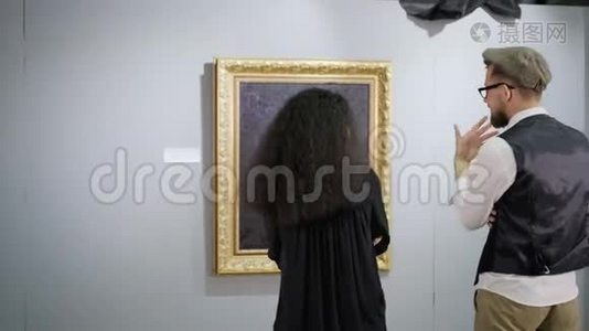 现代艺术展览的参观者在照片前聊天视频
