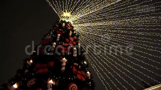 绿色圣诞树顶部的底部视图，夜空背景上有花环和装饰玩具。概念。新的视频