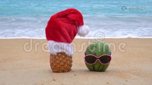 在热带海滩上，菠萝戴着圣诞老人的帽子和戴着太阳镜的绿色欢快的西瓜。 新年和克里斯视频