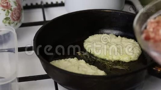 女人用碎肉炸煎饼。 在热炒锅里捣碎土豆。 一个女人把肉末放在上面视频