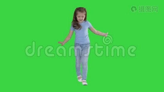 美丽的女孩笑和跳舞，而走在绿色屏幕，Chroma键。视频