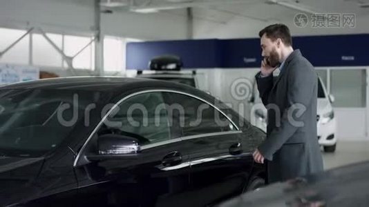 专业的汽车销售人员告诉有兴趣的买家在车展上豪华的汽车，而男人正在与经销商交谈视频