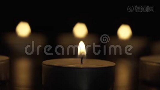蜡烛在黑暗中慢慢燃烧，在三盏灯的背景下视频