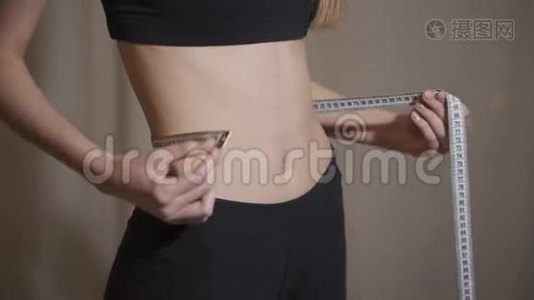 年轻女子用卷尺测量腰部的侧视视频