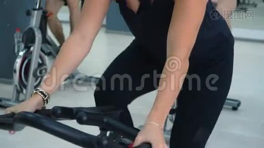 适合女人在自行车课上旋转室内自行车。 在健身俱乐部骑自行车训练的肖像特技女子。 健身人员视频