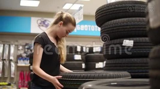 女人为汽车选择轮胎。视频