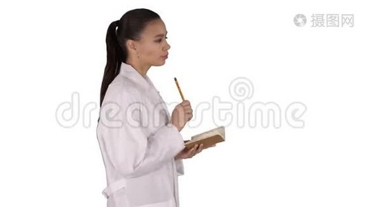 成功的医生在白色背景上行走时做笔记。视频