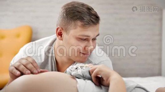 男性未来父母用童鞋触摸裸露怀孕女性腹部的特写脸视频