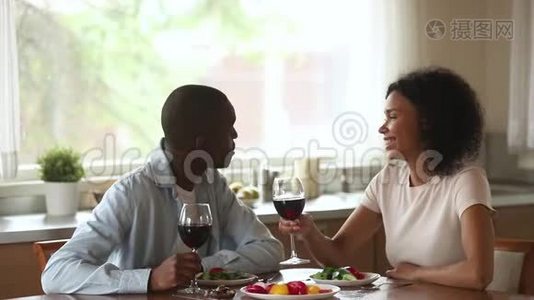 快乐的非洲夫妇喜欢聊天喝酒，坐在桌子上视频