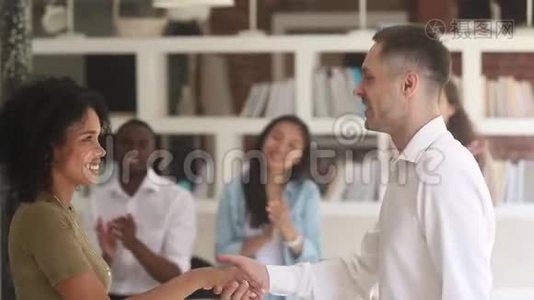 高加索男经理老师握手赞美快乐的非洲女员工视频