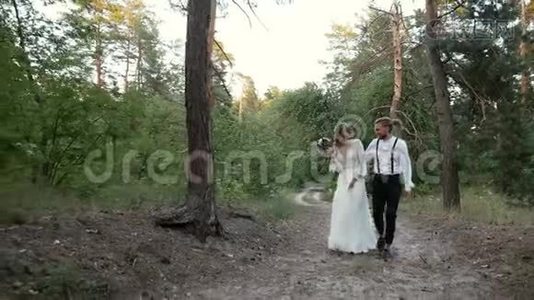 恋爱中的情侣沿着森林路散步视频