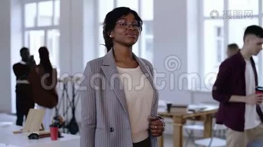 一幅严肃的年轻非洲企业家的肖像，一位戴眼镜、穿着正装的女企业家在现代办公室摆姿势。视频