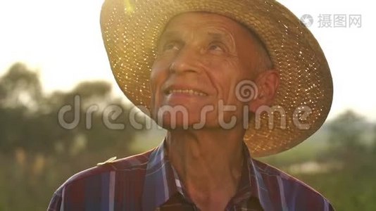 戴草帽的老人微笑着看着太阳慢动作视频