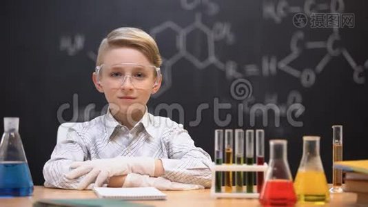 坐在防护眼镜里的小天才，桌子上的管子里有化学液体视频