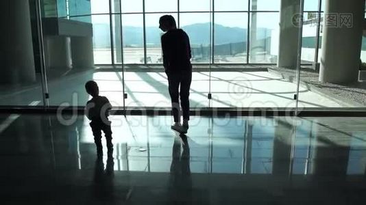 妈妈和小男孩到机场大厅的窗口看飞机视频