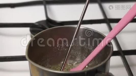 一个人把煮沸的糖浆混合成棉花糖。 他把温度计放进去检查温度视频