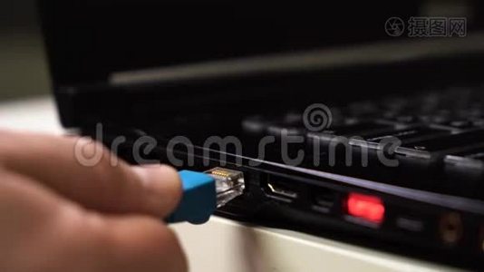 特写男性手连接蓝色以太网电缆笔记本电脑与发光的红色usb端口。视频
