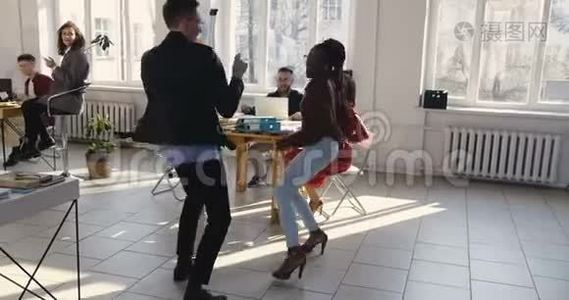 快乐的多民族办公室公司经理在现代健康的工作场所聚会上做有趣的疯狂舞蹈，庆祝成功。视频