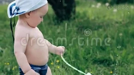 有趣的小男孩在草地上玩着肥皂泡视频