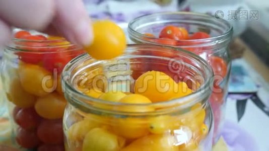 厨房桌上的罐子里放黄色番茄的女性手视频